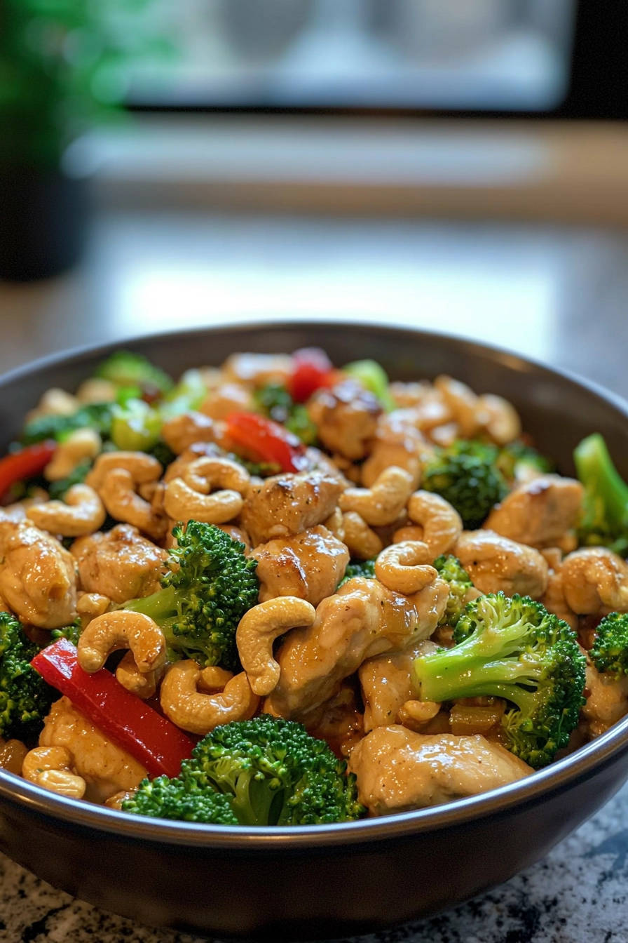 Sunrise glazed cashew chicken served in a deep bowl, showcasing tender chicken pieces, bright broccoli florets, and crunchy cashews.